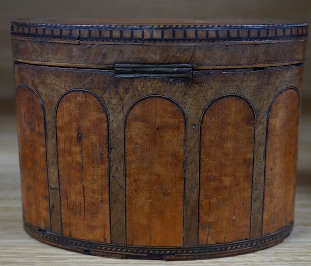 A George III oval satinwood and mahogany tea caddy, 15cm wide. Condition - poor